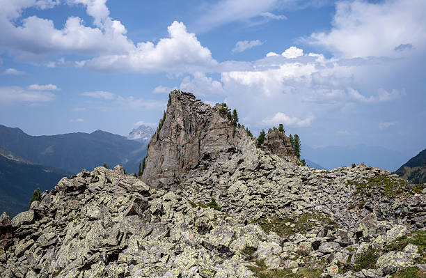 Dramatic rocky summit and scattered stones in high altitude alpine mountain scenery