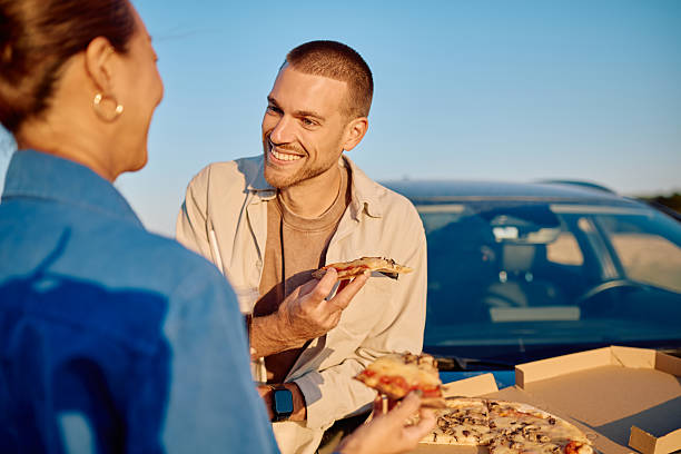 istock Couple eating pizza during a road trip break 2228516698