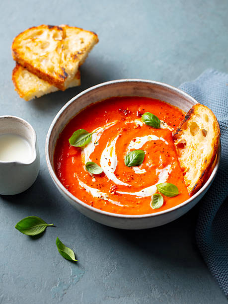 istock Tomato soup with cream in a white bowl on grey stone background. Close up. 2228516726