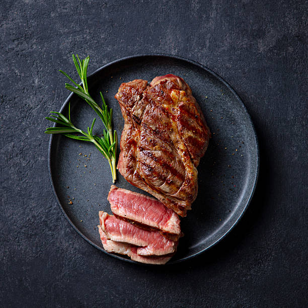 istock Steak medium rare on a black plate. Dark grey background. Close up. Top view. 2228516823