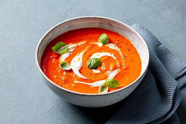 istock Tomato soup with cream in a white bowl. Grey background. Close up. 2228517243
