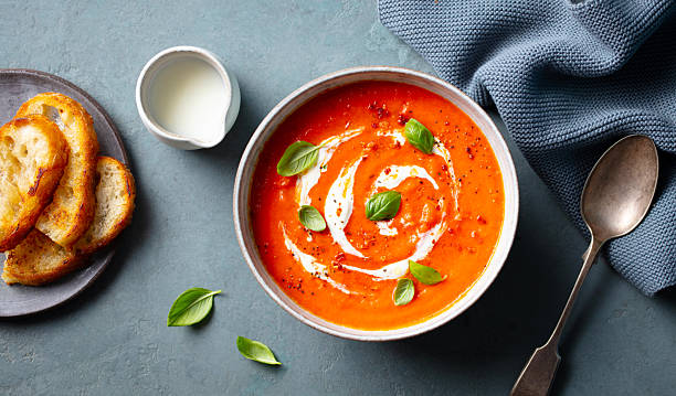 istock Tomato soup with cream in a white bowl on grey background. Close up. Top view. 2228517287