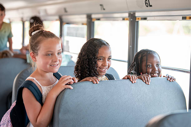 istock Cheerful Children Riding a School Bus on a Sunny Day 2228518218