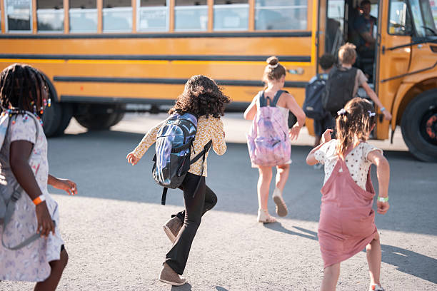 istock Children Boarding a School Bus on a Sunny Day 2228518263