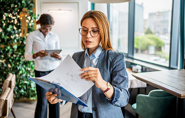 istock Businesswoman reading documents in a modern office cafeteria 2228518757