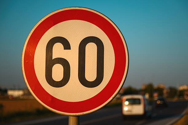 istock Car speeding by the 60 speed limit traffic sign, motion blur image 2228519112