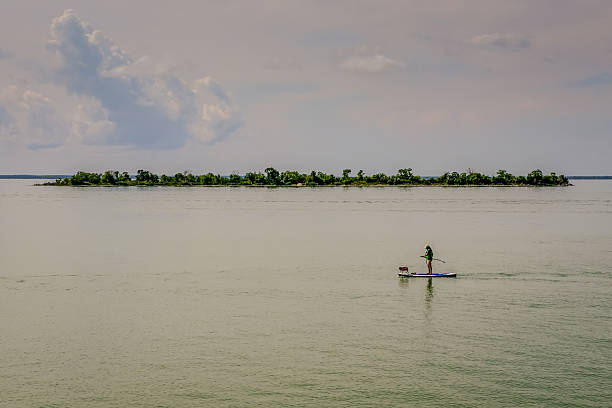 Woman stand up paddling on a calm lake.