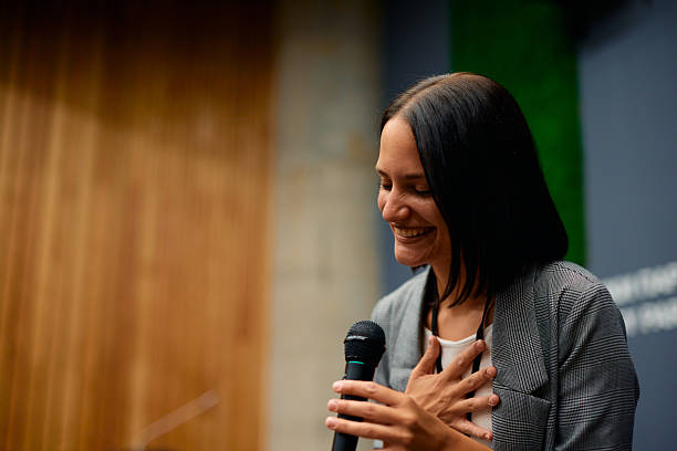 istock Businesswoman laughing holding a microphone during a conference 2228519673