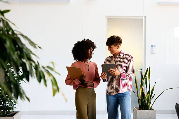 istock Two businesswomen discussing using digital tablet and clipboard in office 2228519677