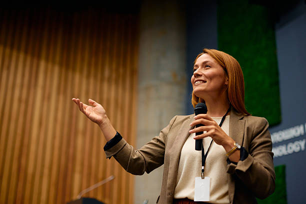 istock Motivational speaker inspiring audience with her speech during a conference 2228519681