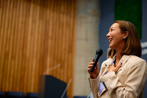 istock Young Asian businesswoman laughing while speaking at a conference 2228519746