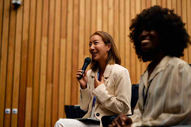 istock Asian businesswoman speaking at a conference using a microphone 2228519815