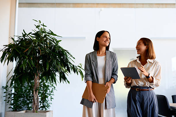 istock Two businesswomen walking and talking in modern office 2228519903
