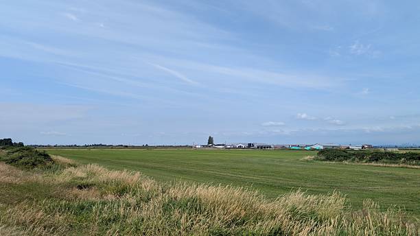 istock green farm land under blue sky with beatiful clouds 2228520389