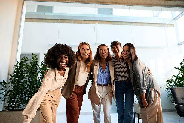 istock Five businesswomen embracing and smiling at the camera 2228520709