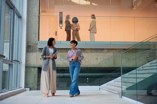 istock Businesswomen talking and holding digital tablets in modern office building 2228522042