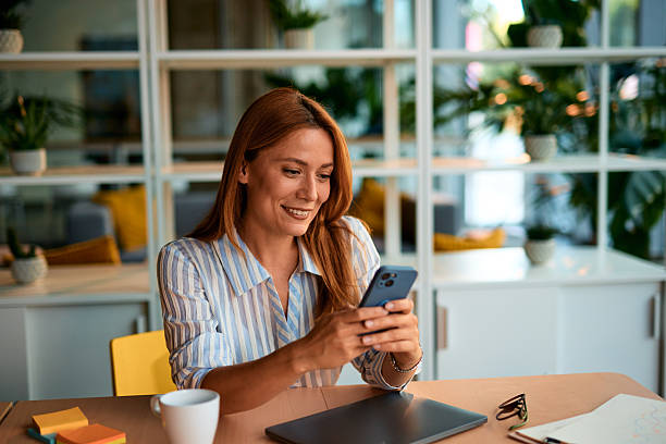 istock Smiling businesswoman using smartphone in modern office 2228522278
