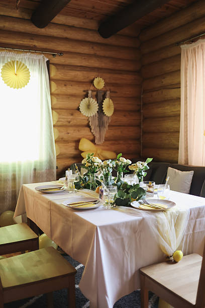 istock Rustic dining room with lemon-themed table decor and floral arrangements. Cozy, natural interior perfect for citrus-inspired events, weddings, or summer celebrations in a wooden cabin. 2228525216