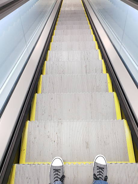 istock Point of View Looking Down at Shoes and Escalator Descent 2228528316