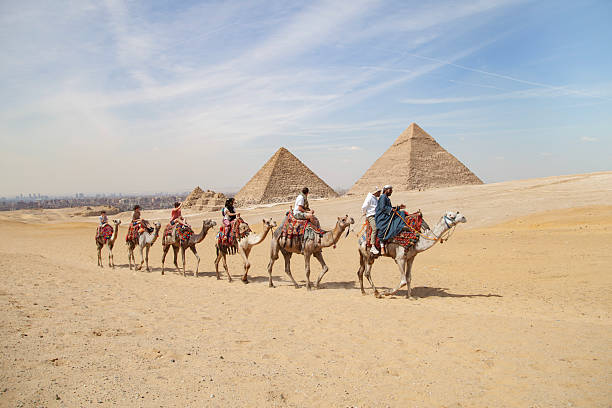 Giza area , Cairo, Egypt- March 15, 2024 Tourists visit the pyramids with camels.