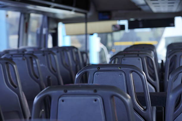 istock Empty bus interior with central aisle - clean, modern public transport. Modern empty bus interior with central aisle - ideal for passenger, tourist and city transportation. 2228530293