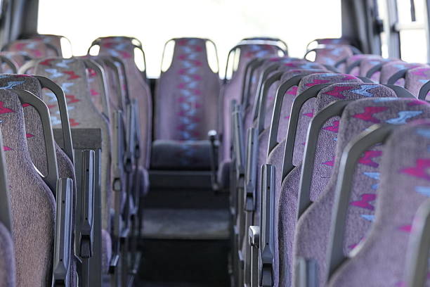 istock Empty bus interior with central aisle - clean, modern public transport. Modern empty bus interior with central aisle - ideal for passenger, tourist and city transportation. 2228530296