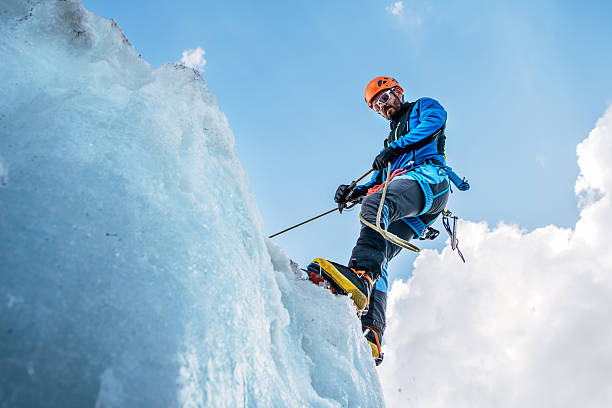 istock Climber in vibrant colors belaying down serac on icy glacier during Lenin peak ascent under clear sky with snow-covered peaks in background. Extreme active people, high-altitude mountaineering concept 2228532208