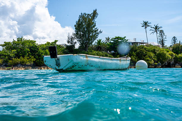 Boat on a Tether Floating in Caribbean Turquoise Waters with Small Island Backdrop