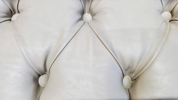 Grey leather armchair with button detail.