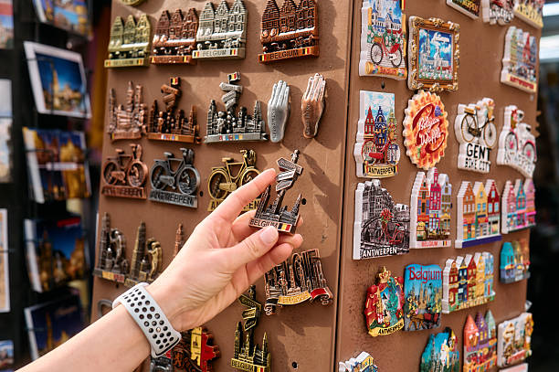 Tourist is choosing souvenir fridge magnets in a shop in belgium