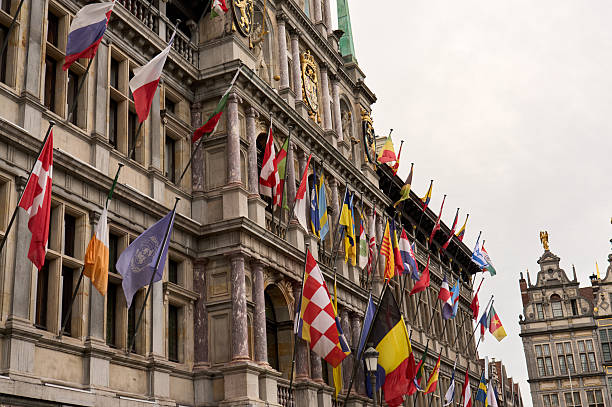 Flags of different countries waving on the facade of antwerp city hall