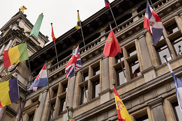 Many different flags waving on the facade of a building in brussels, belgium, celebrating international cooperation