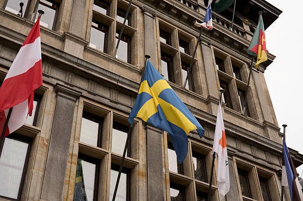 Flags of different countries waving from a government building