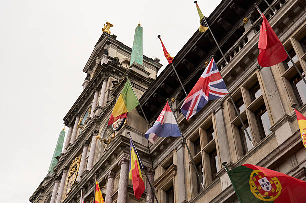 istock Brussels town hall waving multiple european flags on cloudy day 2228537804