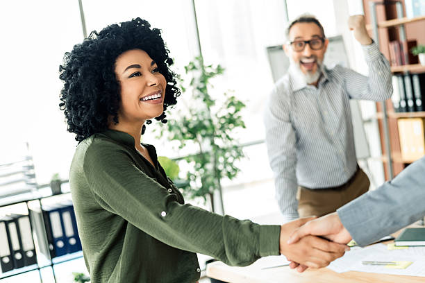 istock Professional coworkers engaging in a joyful business interaction in a modern light-filled office space 2228538563