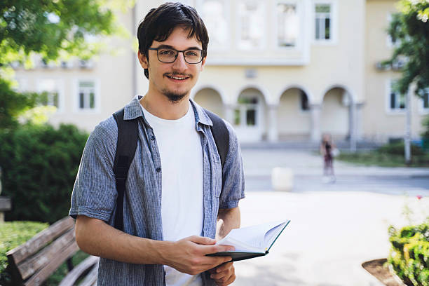 istock Smiling young man holding a book in nature 2228538584