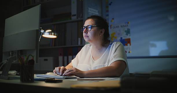 istock Primary School Teacher Working at PC in Empty Classroom Late at Night 2228540030