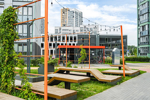 istock Urban park area with modern architecture, greenery, and seating in a city environment during daylight 2228540213