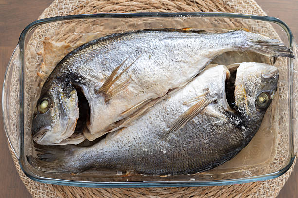 istock Two Freshly Prepared Fish in a Glass Baking Dish for Cooking 2228541011