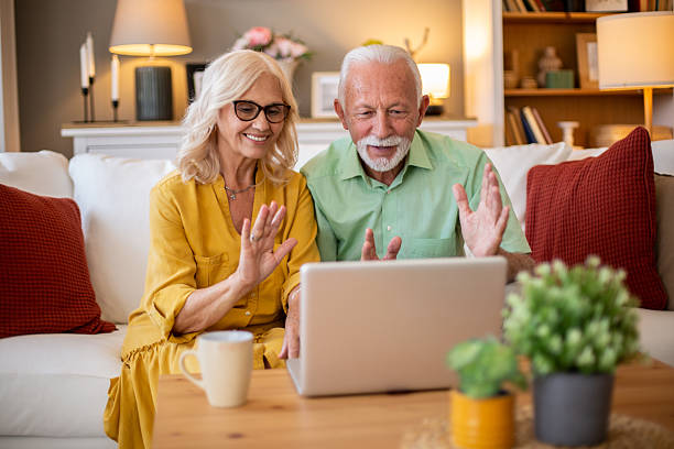 istock Happy senior couple waving at someone during a video call 2228543399