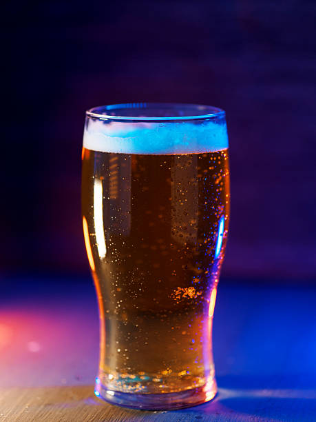 istock Glass of cold beer on table in neon light 2228544826