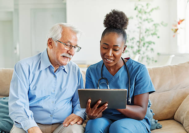 istock nurse doctor senior care tablet computer technology showing caregiver help assistence retirement home nursing elderly woman african american black happy laughing man 2228545030