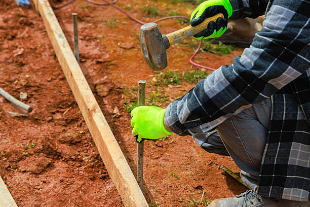 istock Hammering stakes into ground for construction project in residential backyard 2228545382
