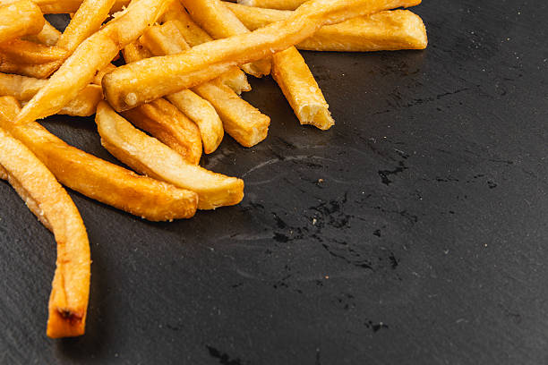 Crispy golden fries on a dark slate surface
