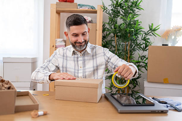 istock Man Packaging Products for Small Business in Work From Home Setup 2228545818