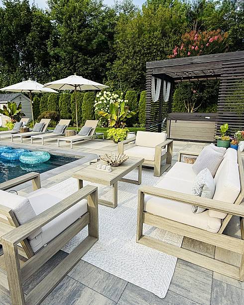 istock Beautiful, luxury, modern backyard lounge area. Umbrella, sofa, lounge chairs table poolside. Hotel resort feel. Seating and tanning sundeck by gray stone pavers. Inspired by Tulum, Mexico. High end. 2228545838