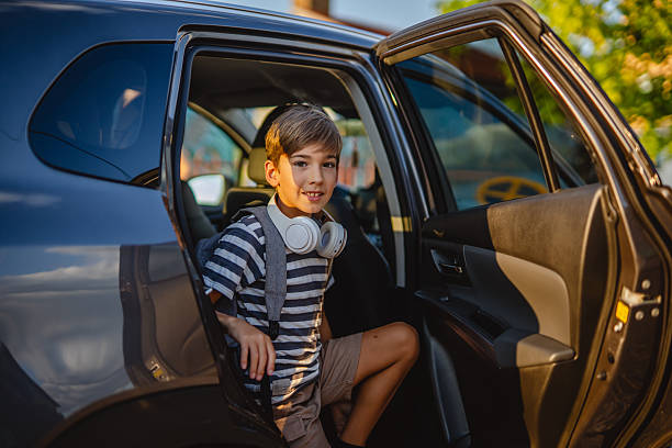 istock Young boy with headphones exiting a car 2228547279