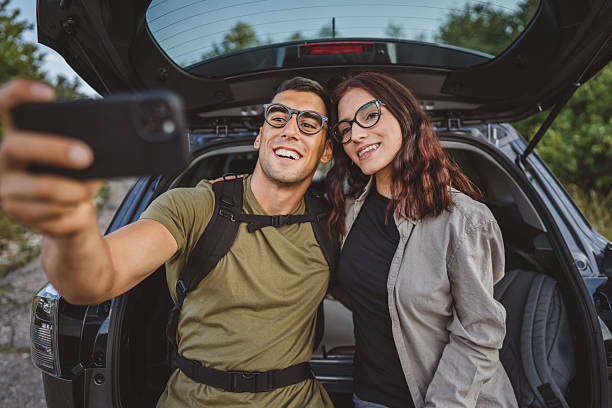istock Hikers couple taking selfie with smartphone at car trunk 2228547425