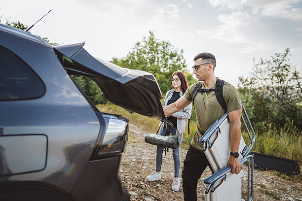 istock Hikers unpacking camping gear from car trunk 2228547487