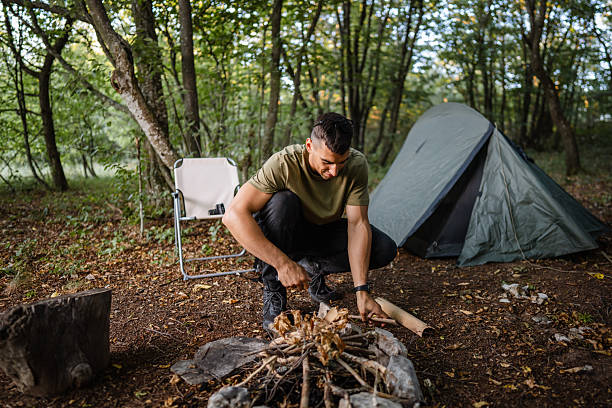 istock Hiker preparing campfire in forest next to tent 2228547743